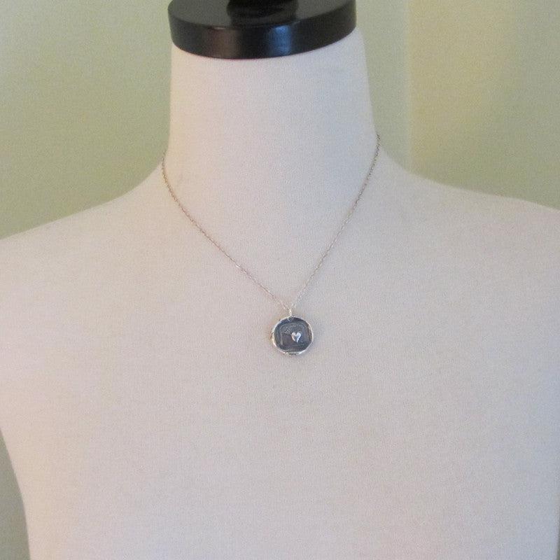 Love hurts wax seal necklace on a mannequin