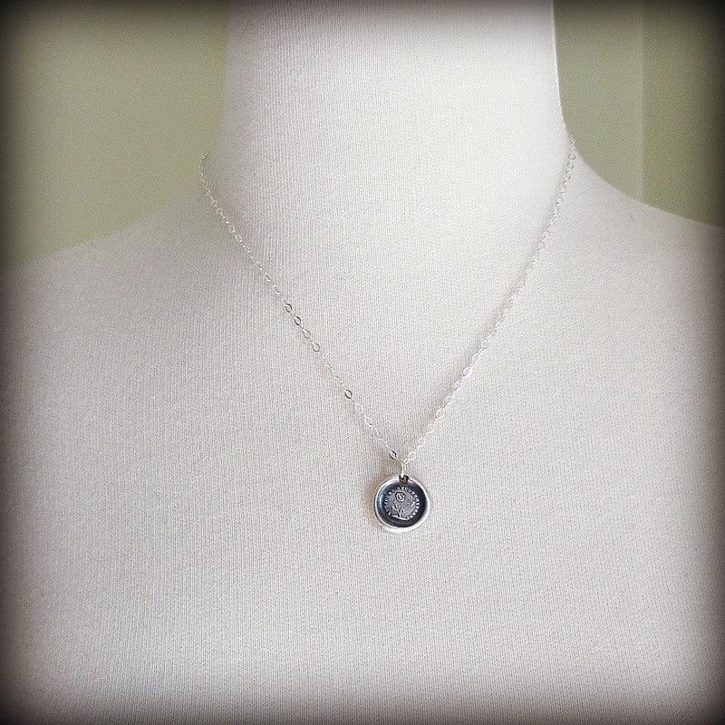 Flower and sun wax seal necklace on a mannequin