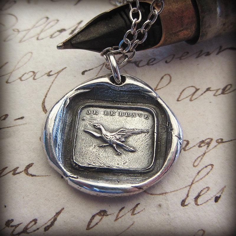 Eagle soaring wax seal necklace hanging over a pen