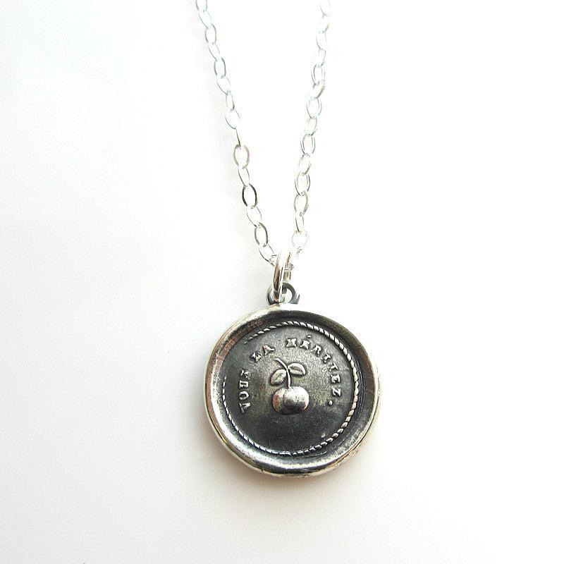 Cherry wax seal necklace on a white background