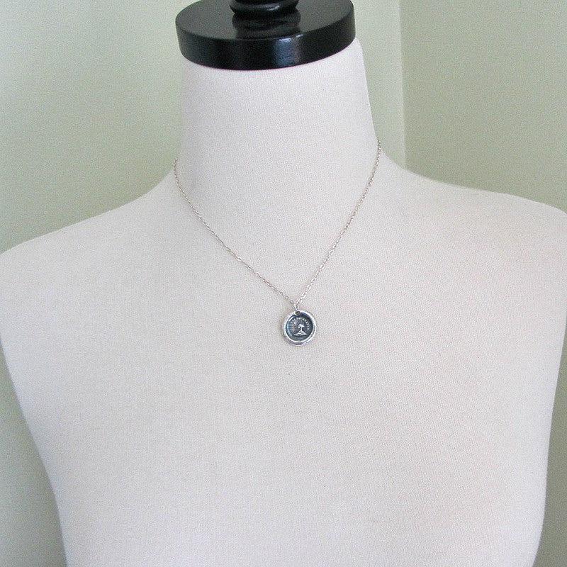 Tree and sun wax seal necklace on a mannequin