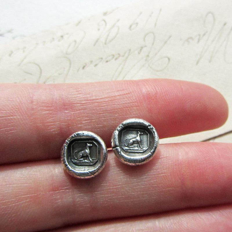 Greyhound Wax Seal Stud Earrings in fingers