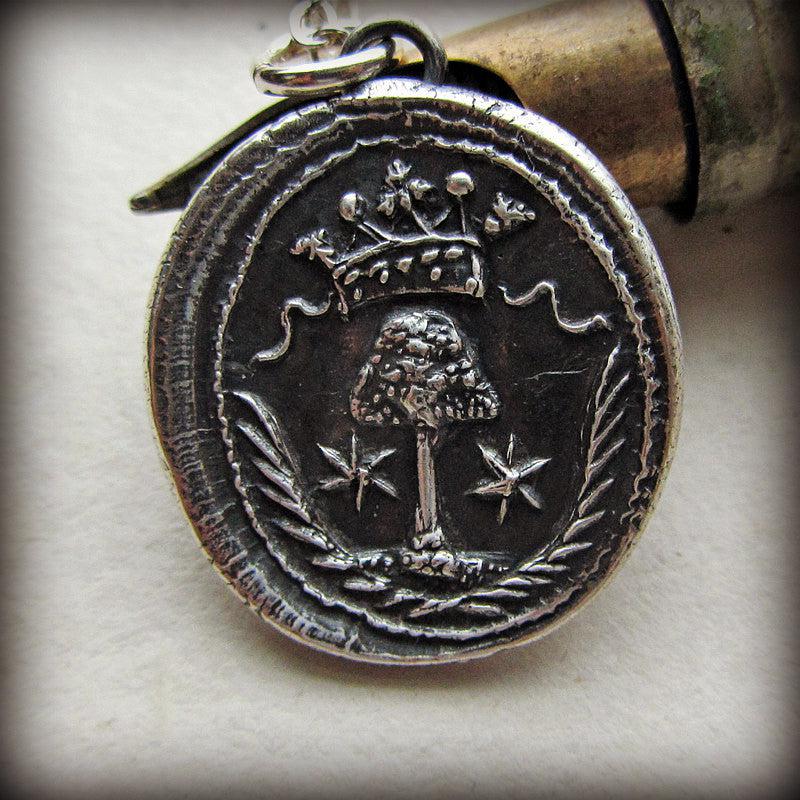 Family tree wax seal necklace over a pen