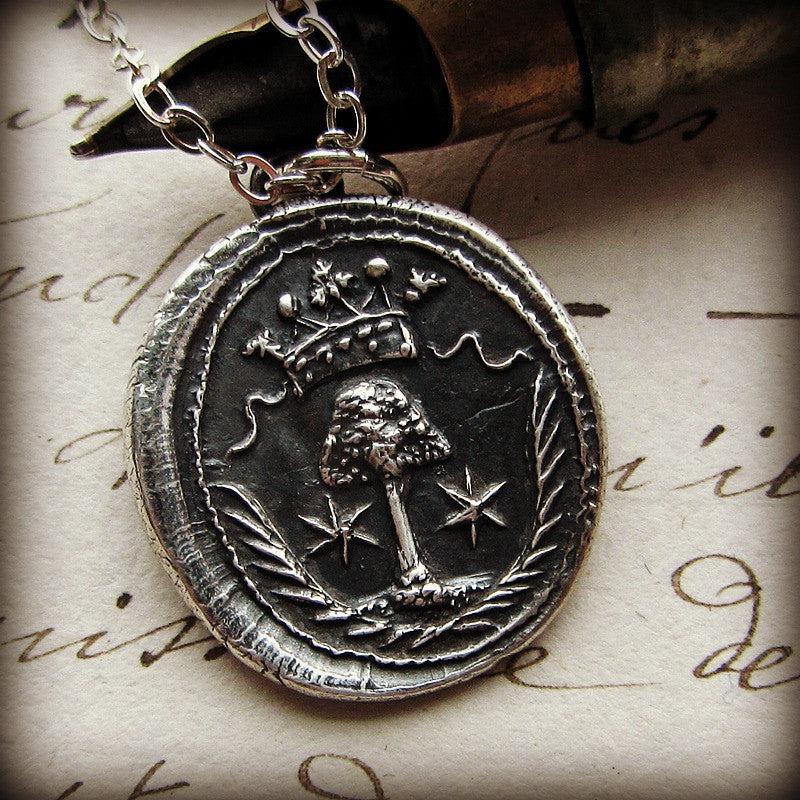 Family tree wax seal necklace next to stamp