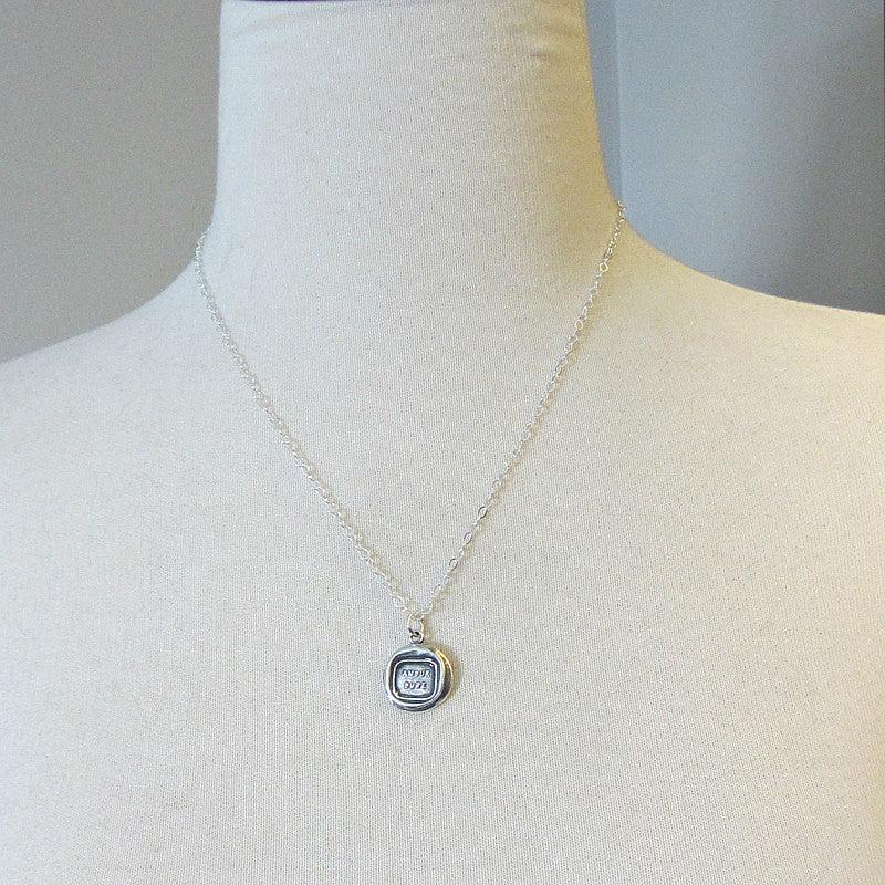 Love lasts french wax seal pendant on a mannequin