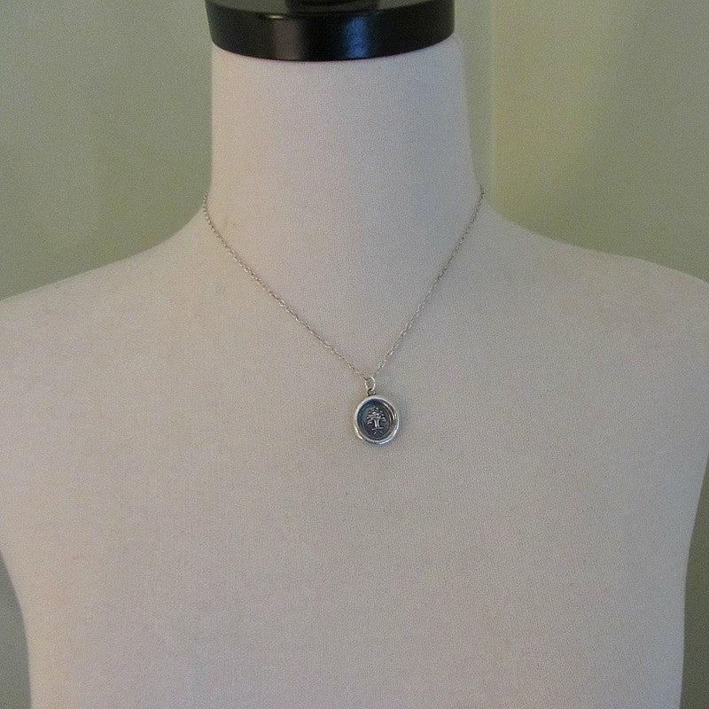 The Oak and The Acorn wax seal necklace on a mannequin