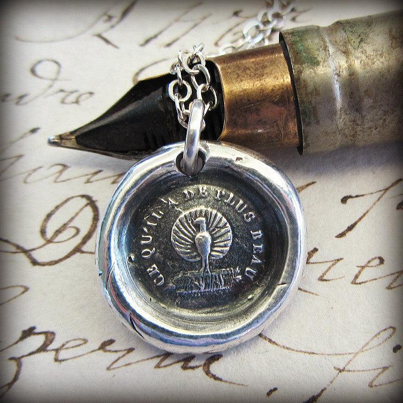 Peacock Wax Seal Necklace over a pen