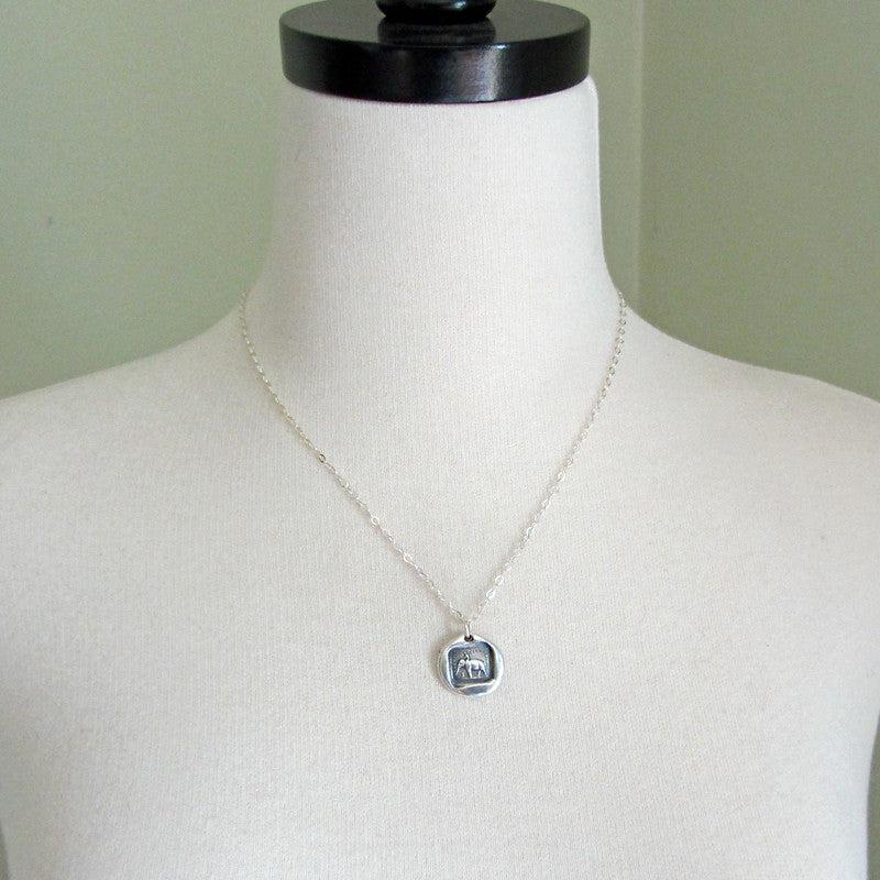 Guy riding an elephant wax seal necklace on a mannequin