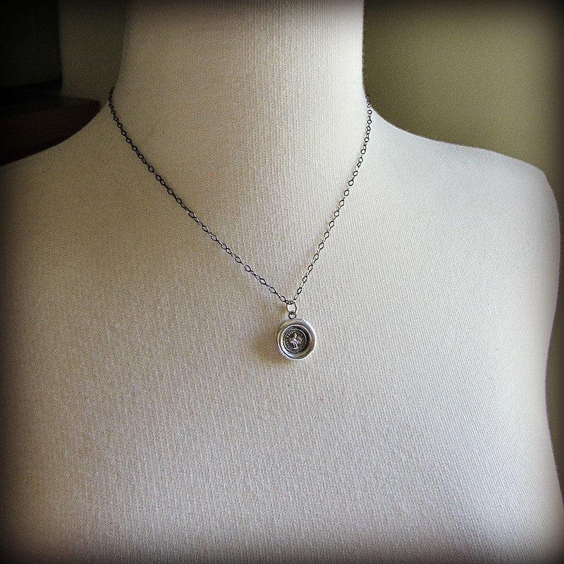 While I Live I&#39;ll Crow Wax Seal Necklace on a mannequin