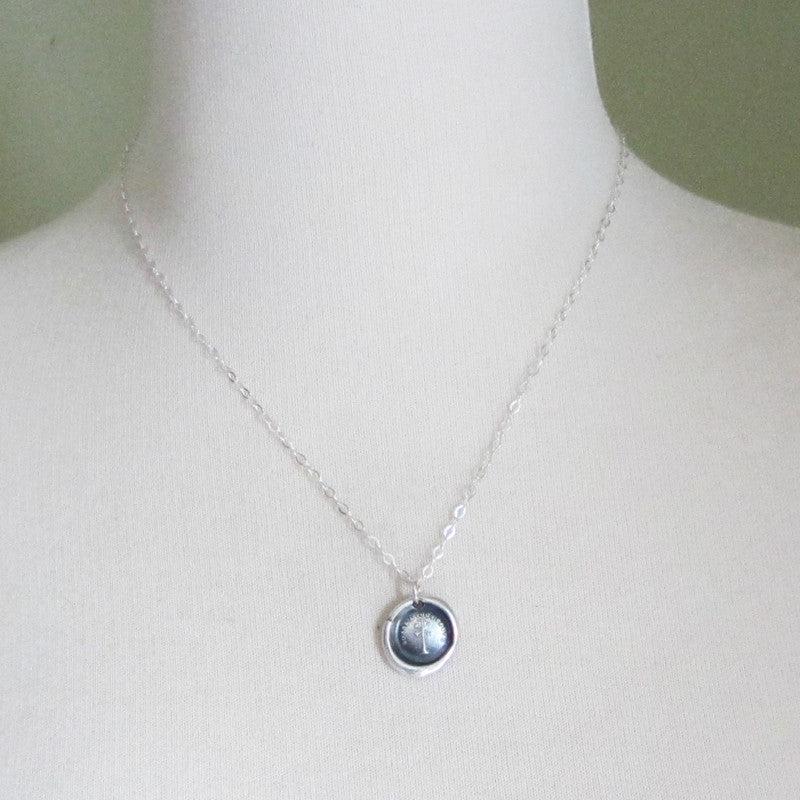 Weather vane wax seal necklace on a mannequin