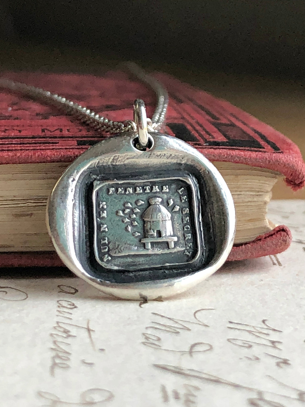 Beehive wax seal necklace on a book