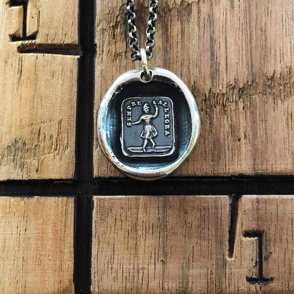 Always glad wax seal necklace on a wood background