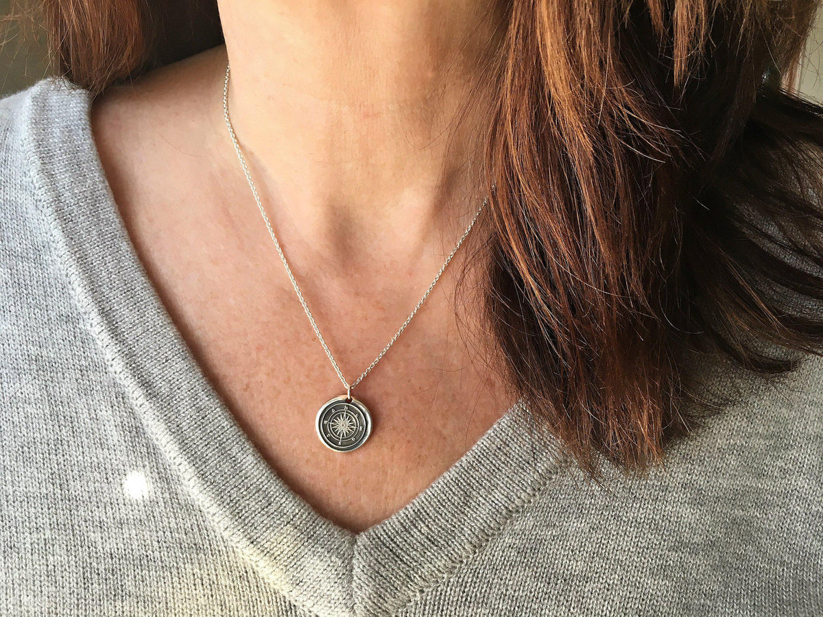 Compass wax seal necklace on a model