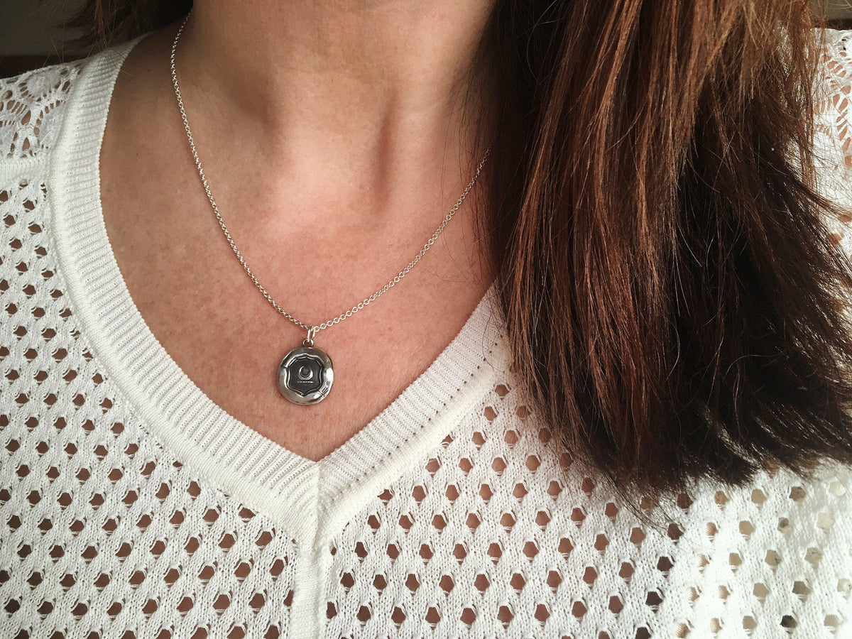 Crescent moon wax seal necklace on a mannequin