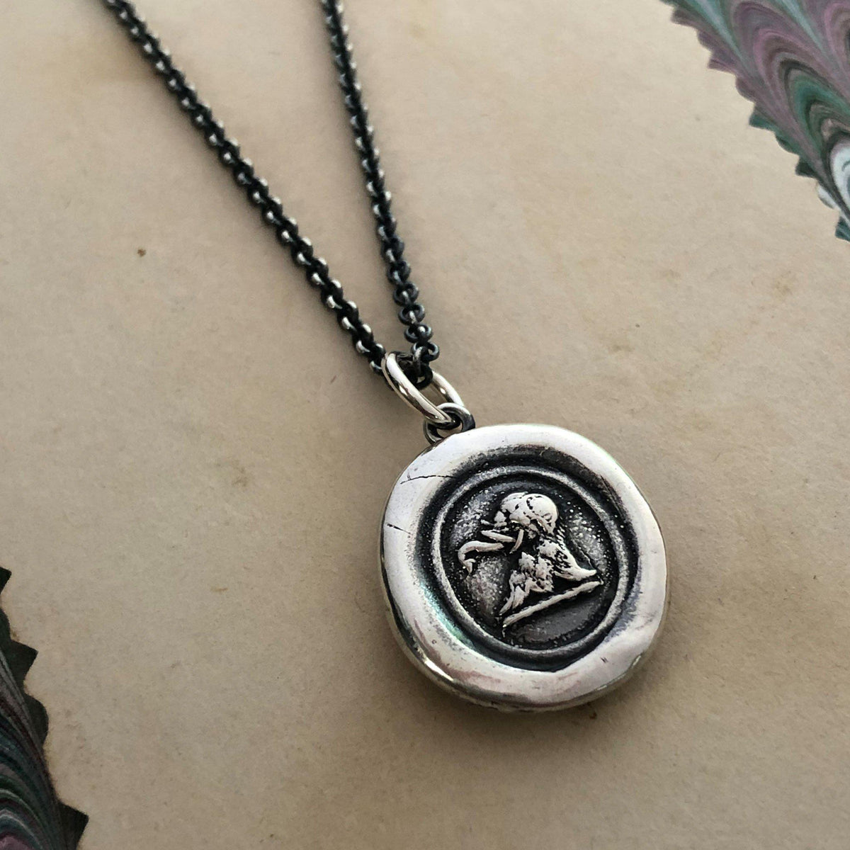 Elephant wax seal necklace close with a dark chain