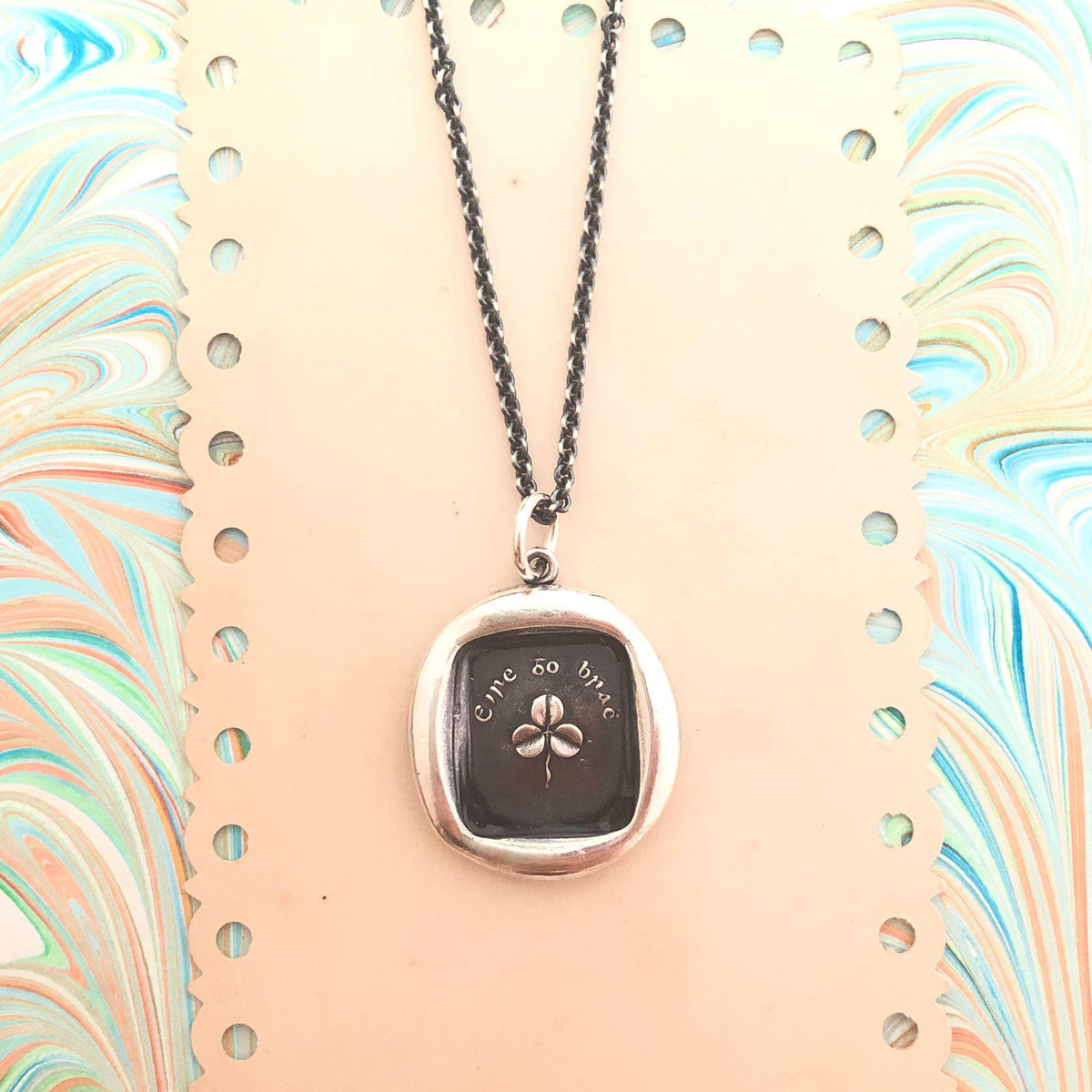 Shamrock wax seal necklace on paper