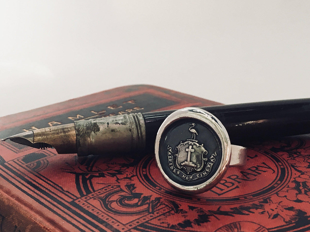 Faith wax seal ring in front of a pen