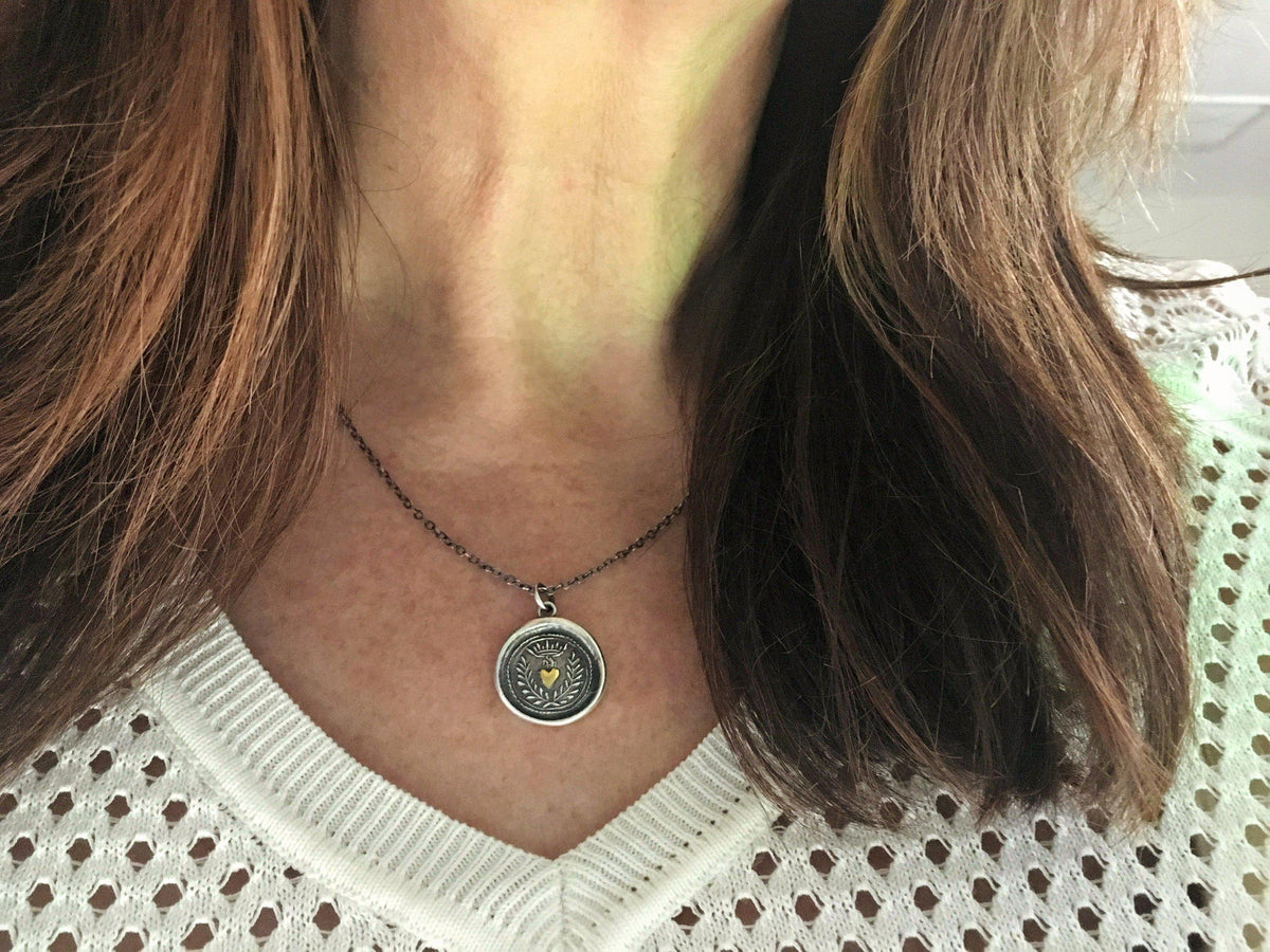 Flaming Gold Heart Wax Seal Necklace on a model 