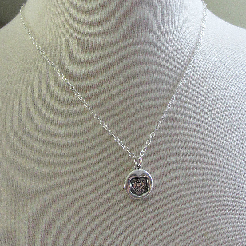 flower forget me not wax seal necklace on a mannequin