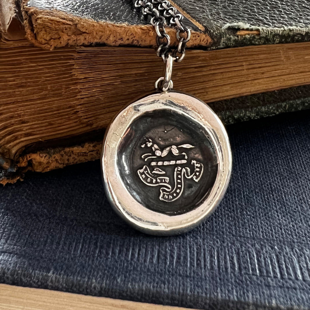 Fox charm wax seal necklace on a book