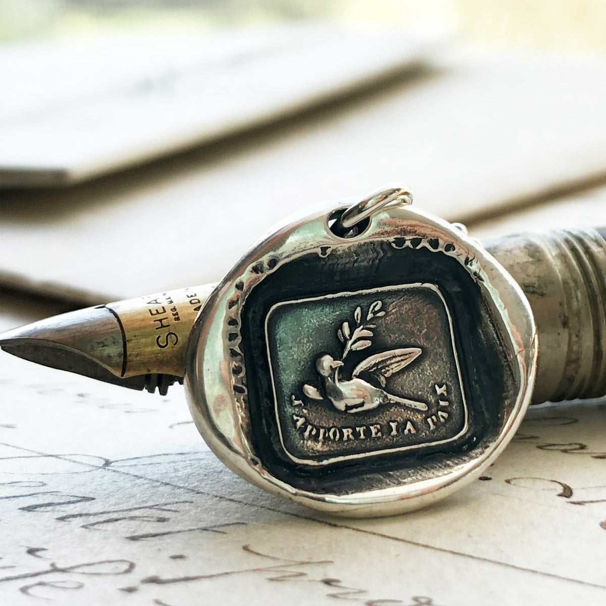 Peace dove necklace on a pen