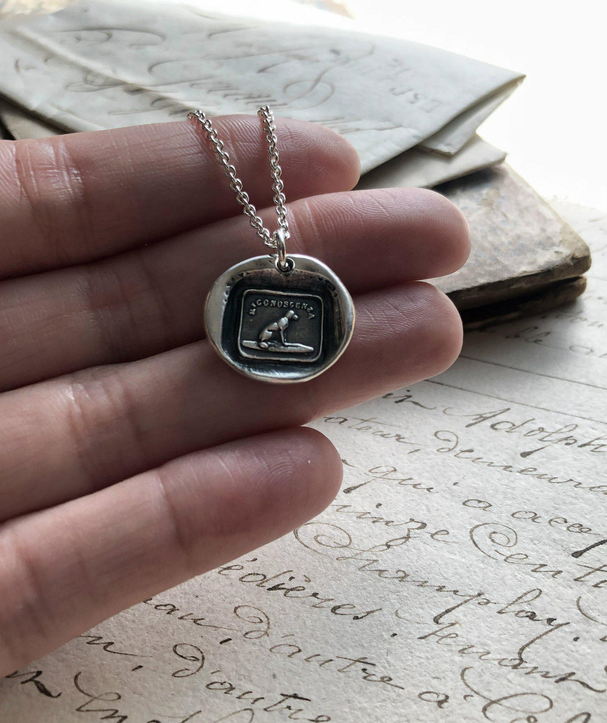 Gratitude dog wax seal charm in a hand