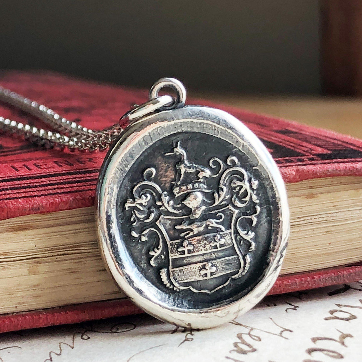 Greyhound crest necklace on a book