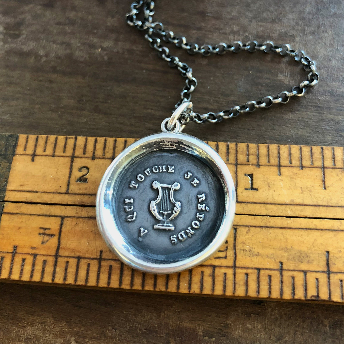 Harp wax seal necklace on a ruler