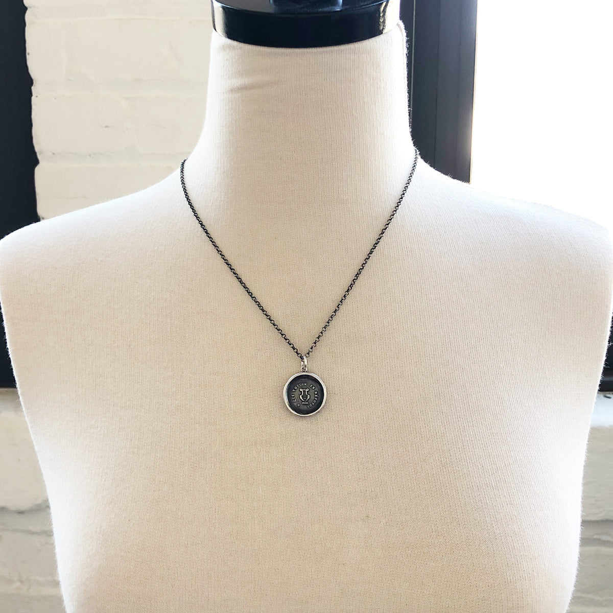 Harp wax seal necklace on a mannequin