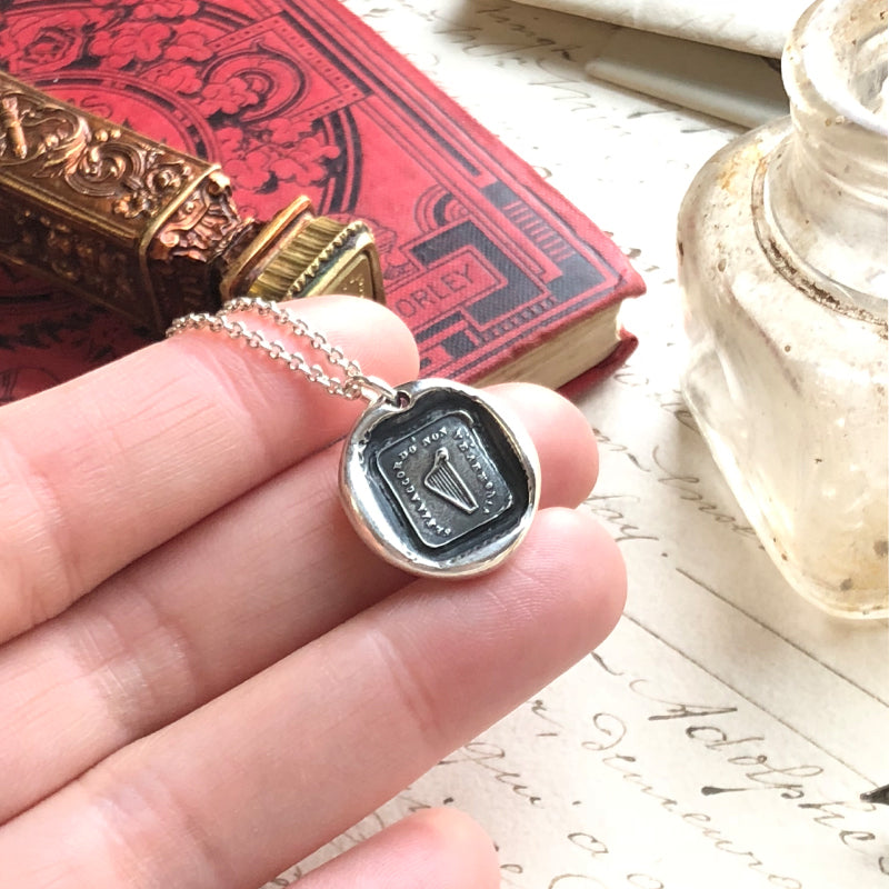 harp wax seal necklace in hand