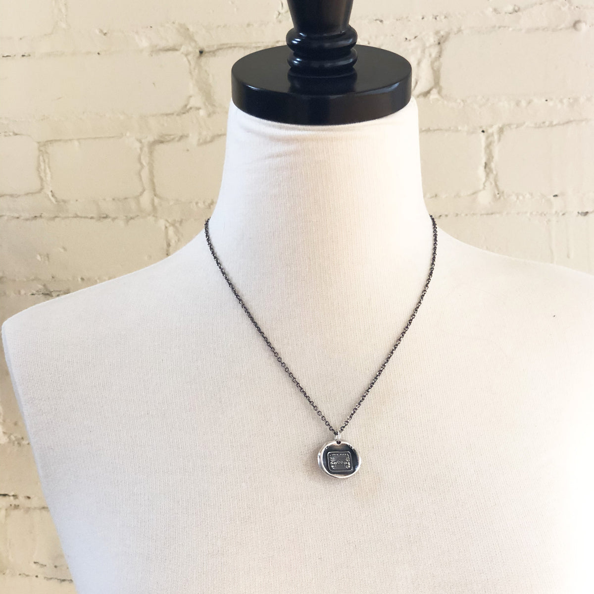 Long distance wax seal necklace on a mannequin