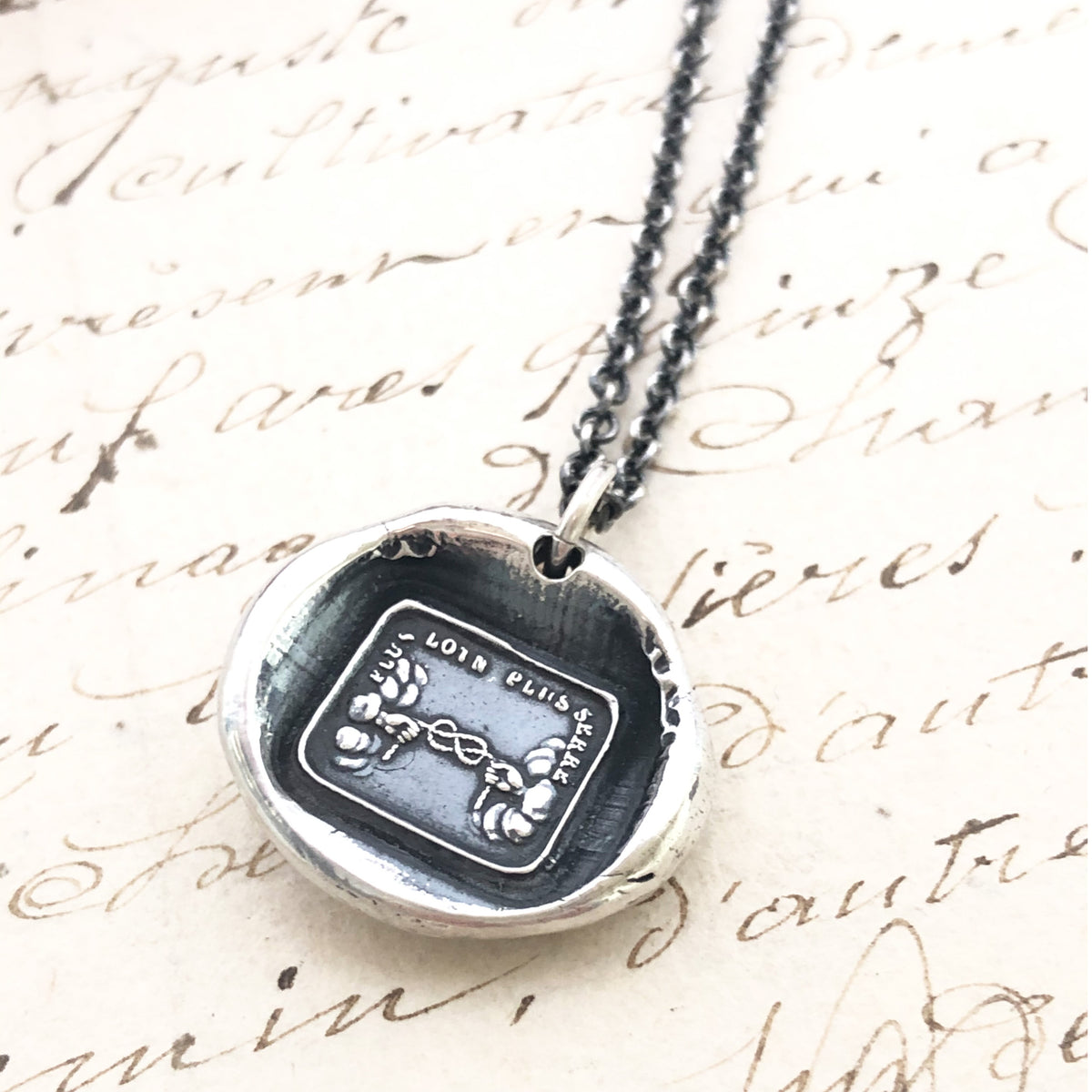 Long distance wax seal necklace with a dark chain