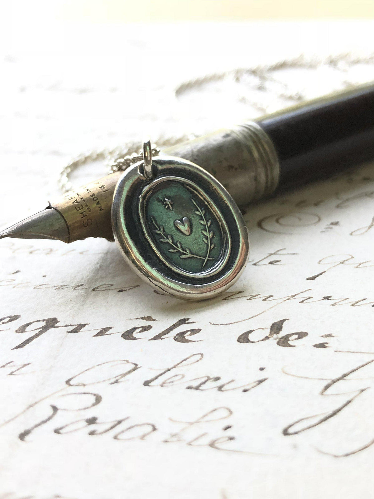 Heart with a star wax seal necklace on paper