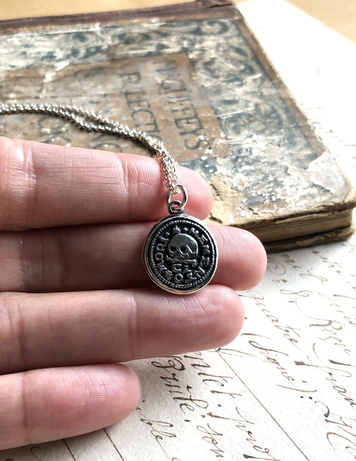 Skull on this wax seal necklace in hand