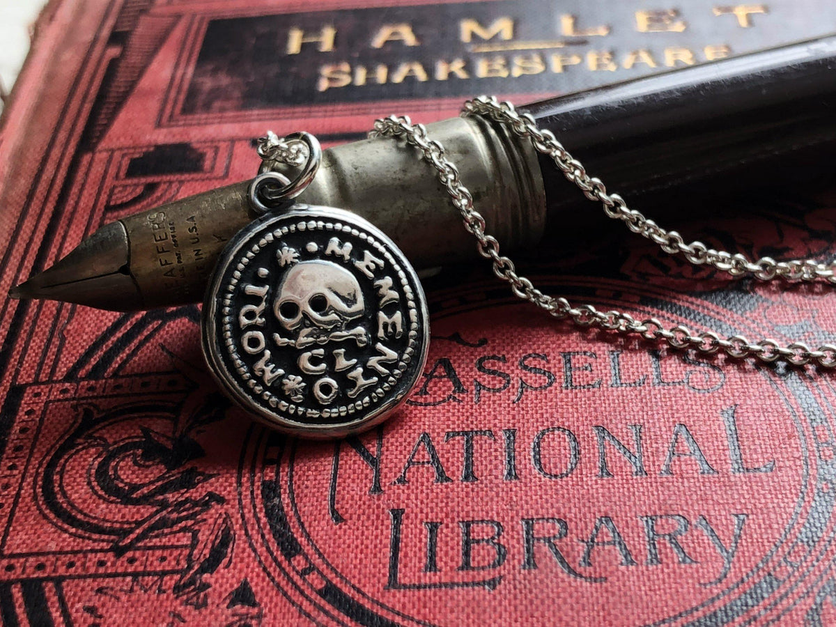 Skull on this wax seal necklace over a pen