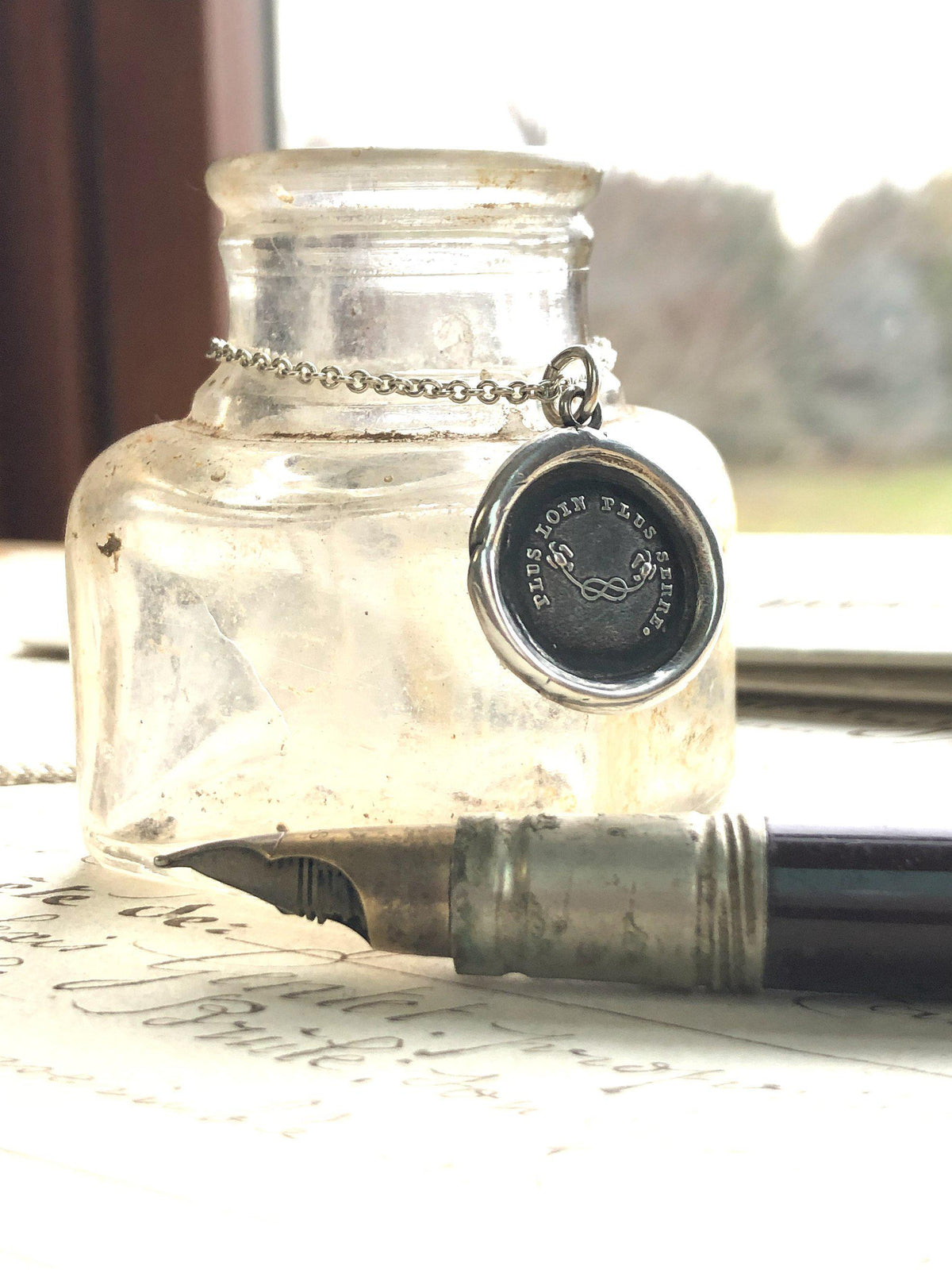 Mothers knot wax seal necklace on a jar