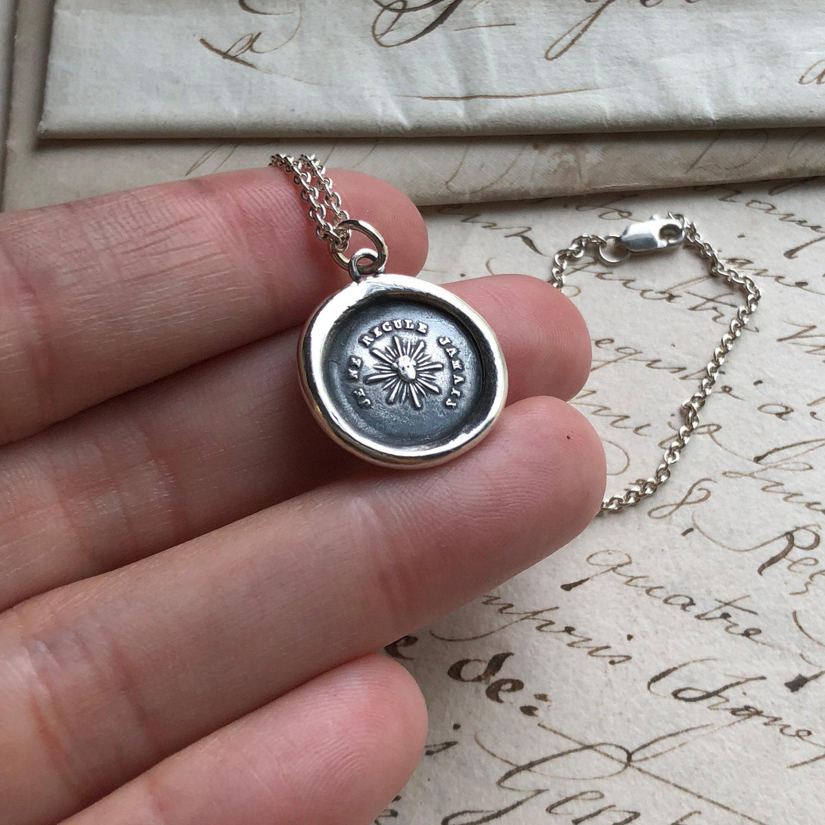 Never back down wax seal necklace in a hand