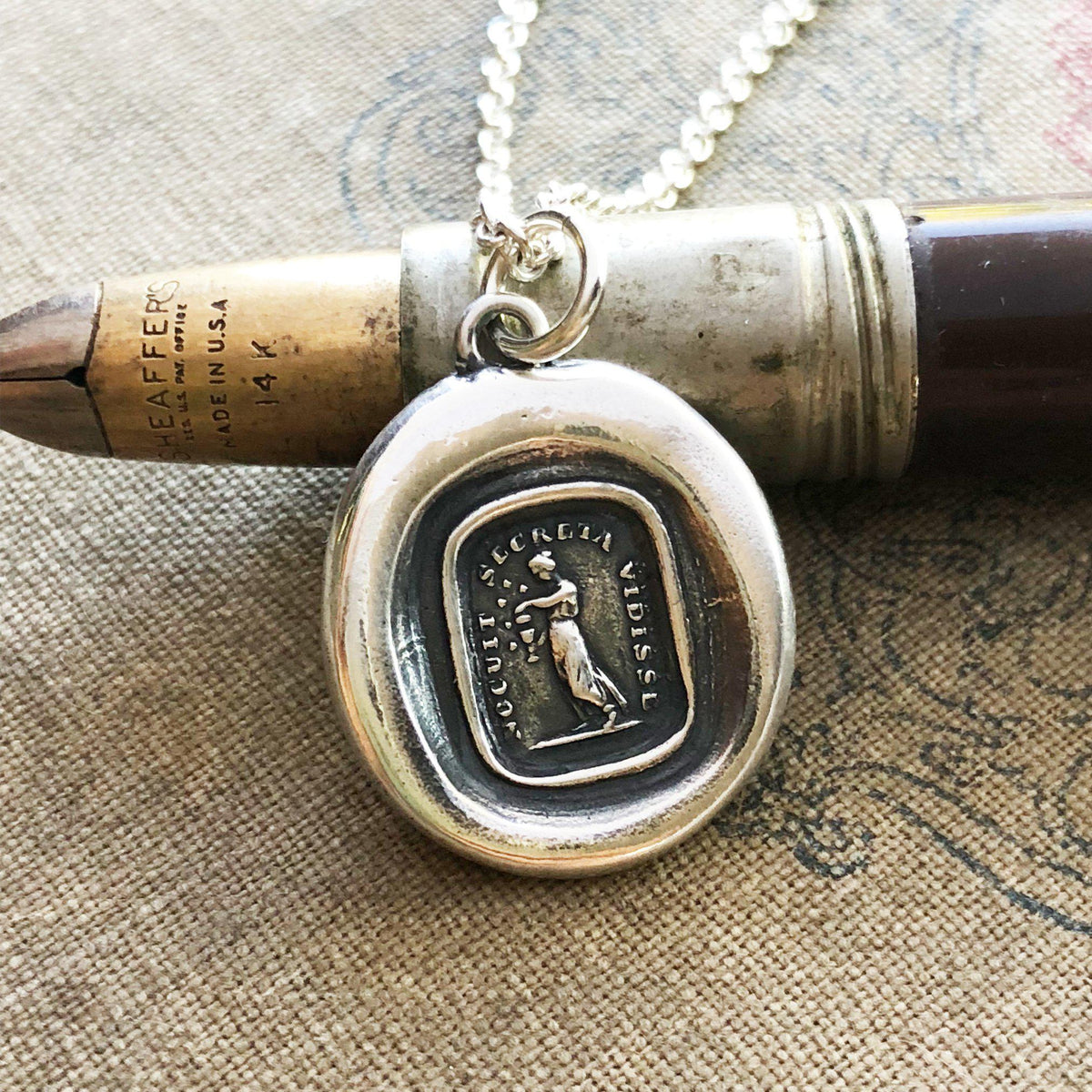 Pandora box wax seal necklace over a pen