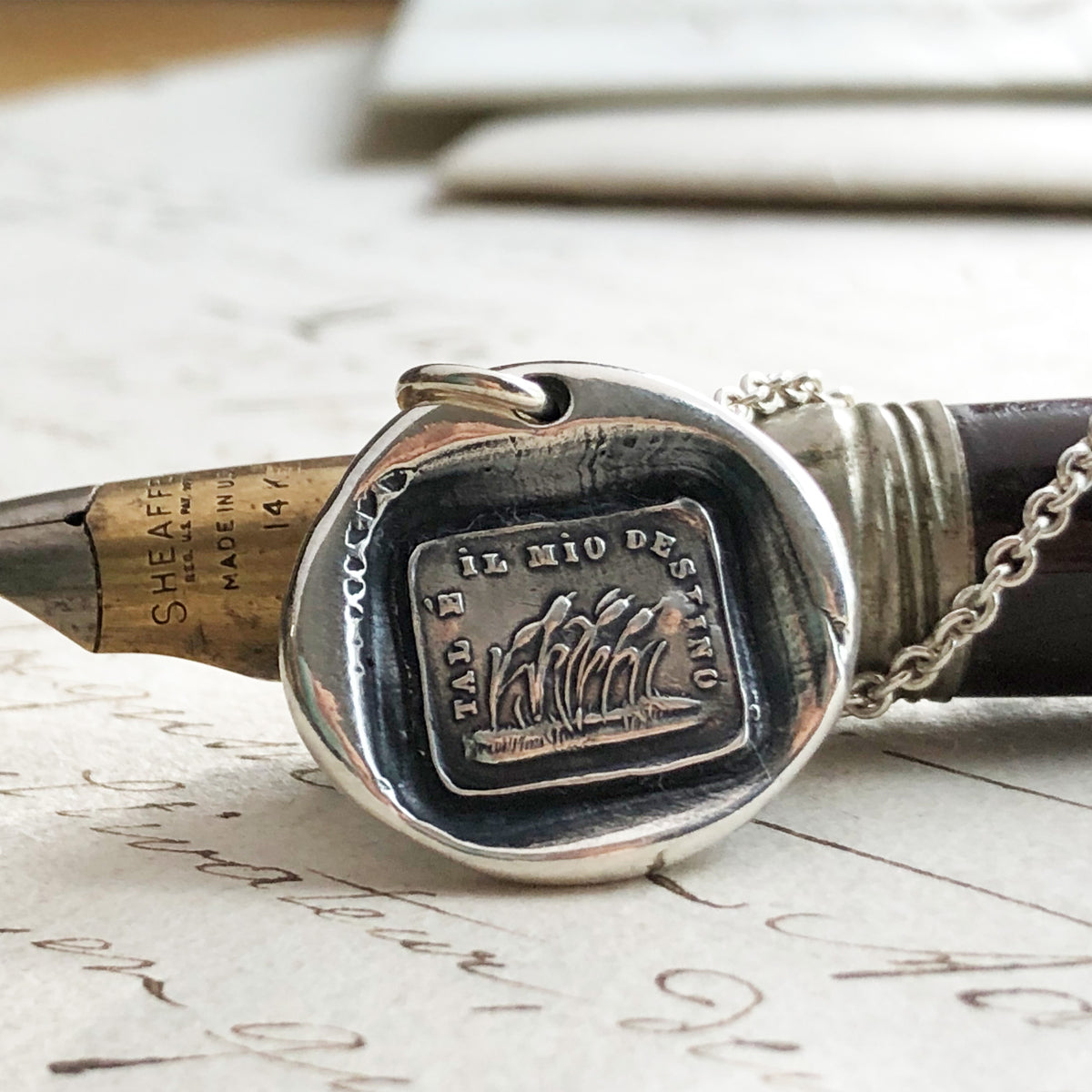 Resilence wax seal necklace on a pen