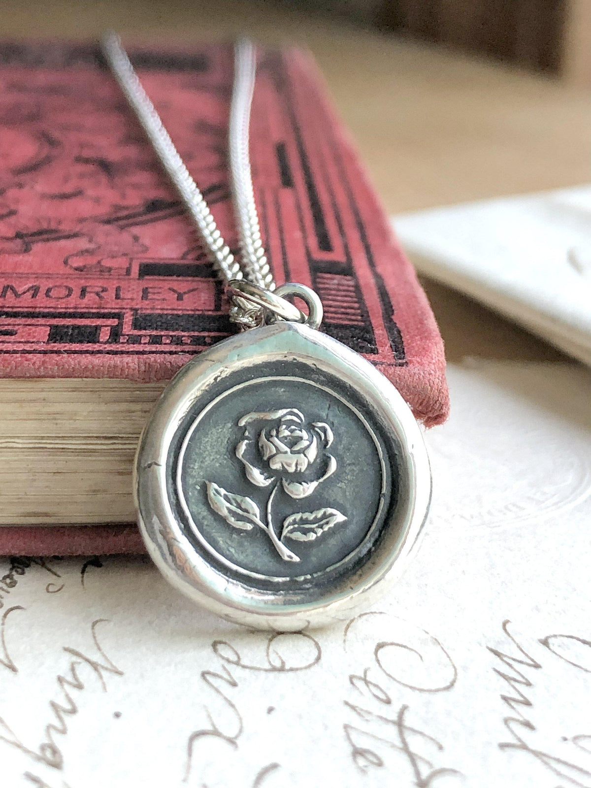 Rose wax seal necklace on a book