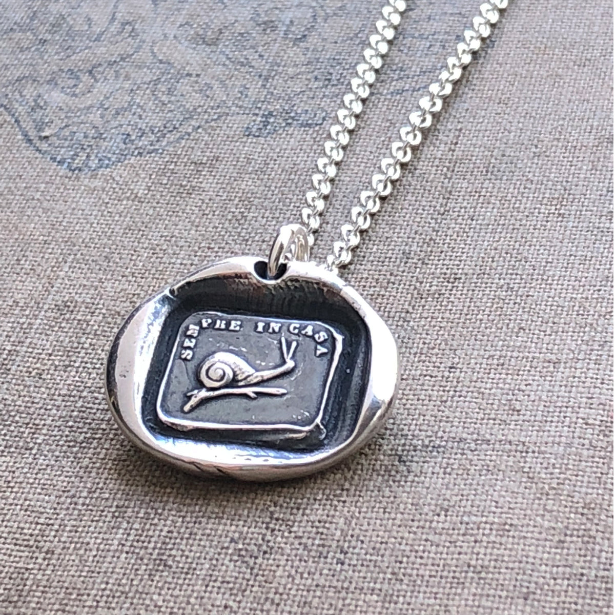 Snail wax seal necklace carpet