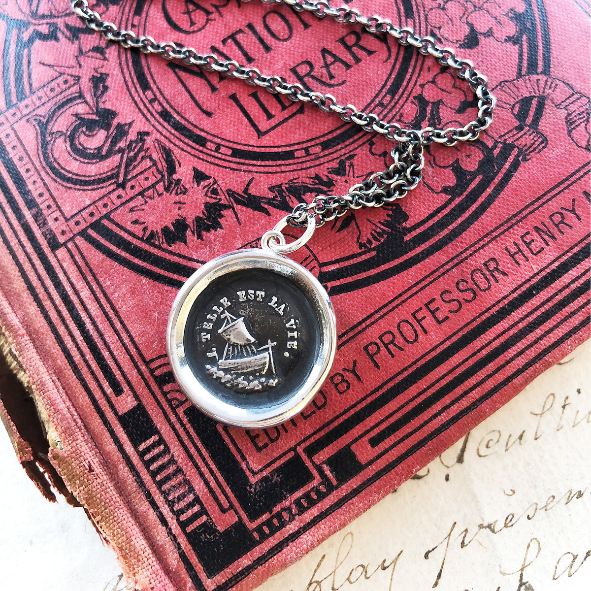 Such is life wax seal necklace on a red book