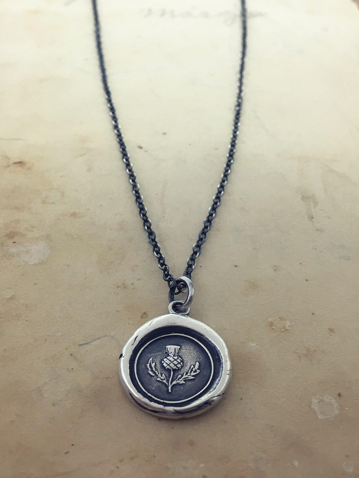 Scottish Thistle wax seal necklace on table