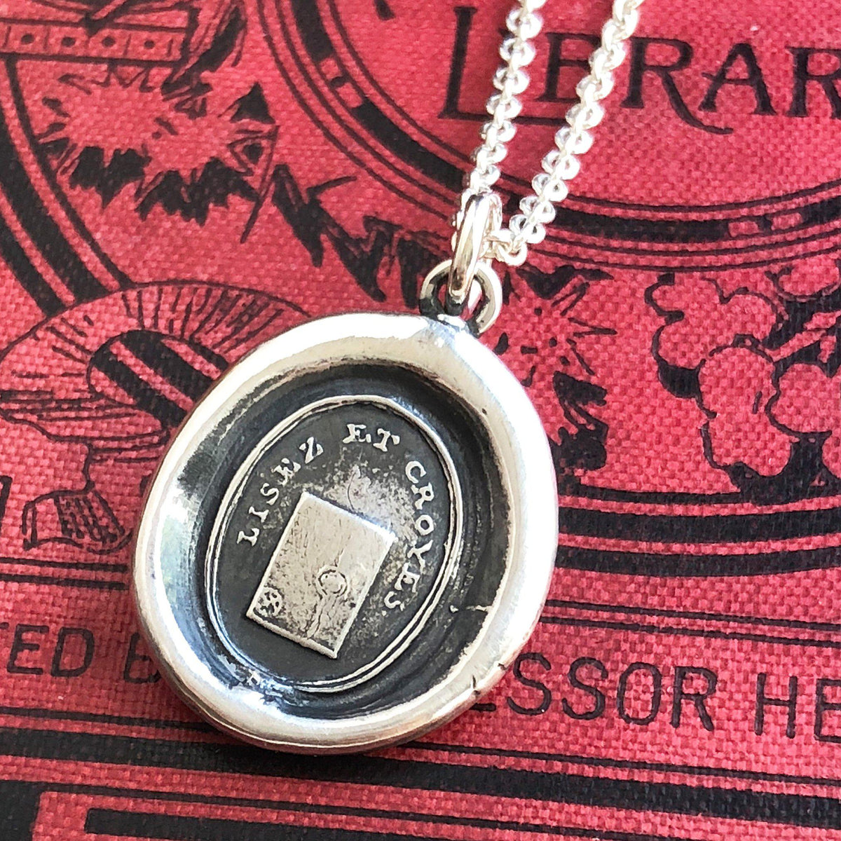 Truth and sincerity wax seal necklace on a red book