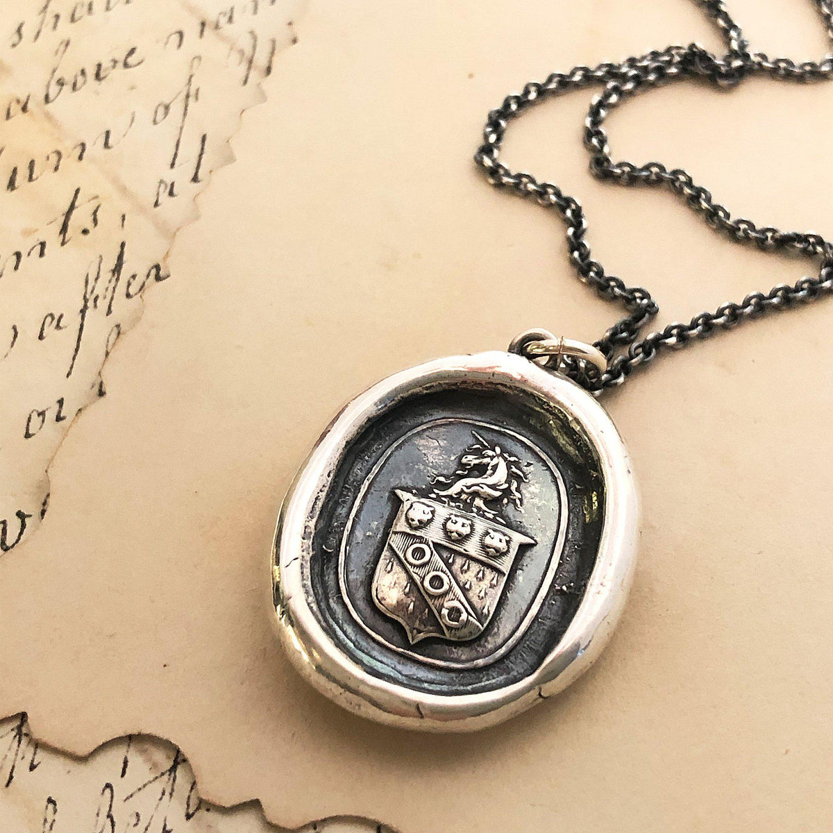 Unicorn crest wax seal necklace on paper