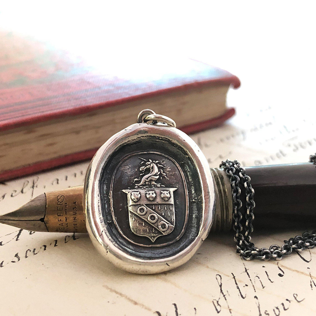 Unicorn crest wax seal necklace on a pen